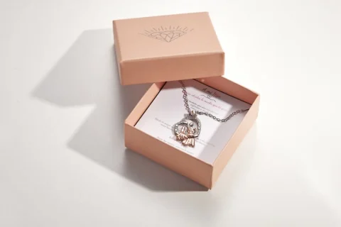 La caja de regalo abierta, con el collar y la tarjeta dentro